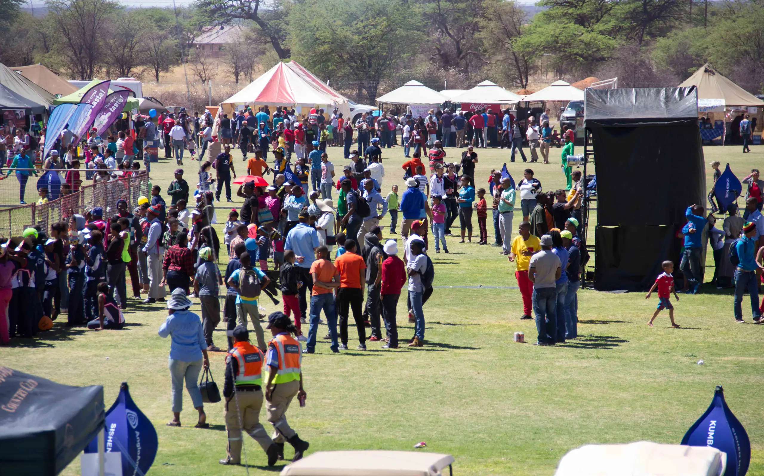 A festival on a lawn: crowds, marquees and a sound tower